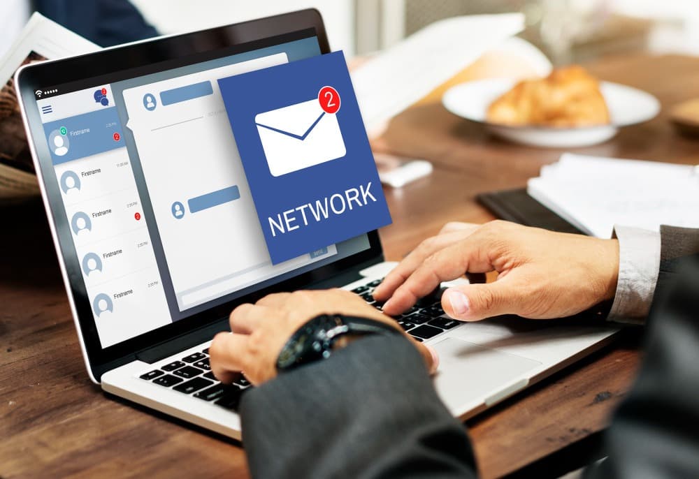 Ảnh chụp một người đang sử dụng laptop, trên màn hình hiển thị giao diện một ứng dụng email